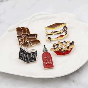 Creative enamel pins set featuring sofa, smore, poutine fries and spice bottle on a tray
