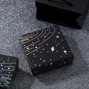 Detailed view of black jewelry gift box and paper bag with laser starry sky patterns