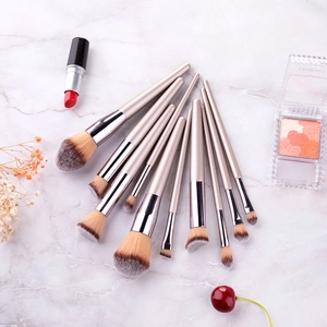 Detailed set of 10 champagne gold makeup brushes on elegant white marble background