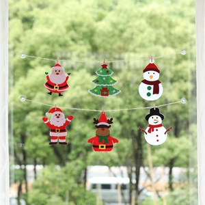 Christmas felt ornaments set with Santa and reindeer hanging on window glass using wood clips