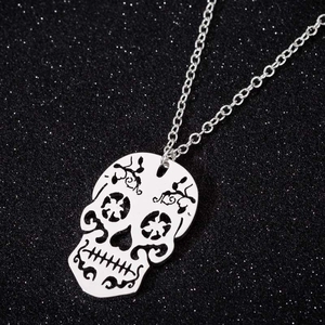 Vintage hollow silver skull pendant necklace with intricate patterns on black background
