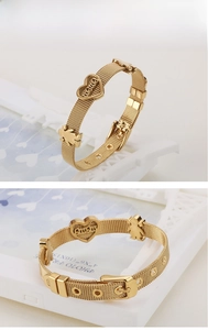 Détail du bracelet en maille d'acier doré avec pendentif cœur et fermoir à boucle