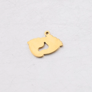 Macro view of gold-colored baby footprints pendant with polished mirror finish and jump ring
