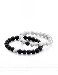 Detail of beaded stretch bracelets featuring matte black agate and white turquoise stones