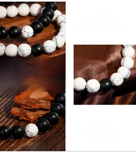 Detail of beaded bracelet with matte black onyx and white turquoise on rustic wood