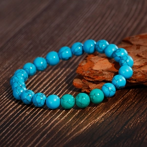 Fashion turquoise beaded bracelet with natural black veins on rustic wood background