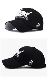 Close-up of black cotton baseball cap showing detailed white letter embroidery and stitching