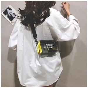 Detail of transparent black crossbody bag with yellow strap and fashion typography