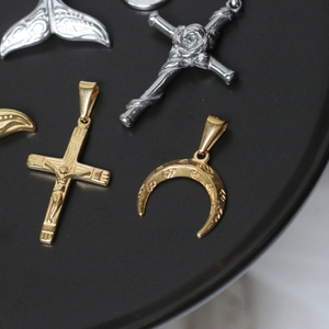 Detail of vintage 18K gold plated whale tail and crescent cross pendant charms