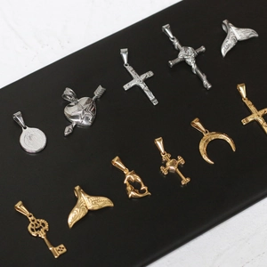 Detailed close-up of vintage coin, mermaid tail, and cross pendants in gold and silver