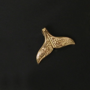 Detailed view of an 18K gold-plated stainless steel mermaid tail pendant with embossed texture
