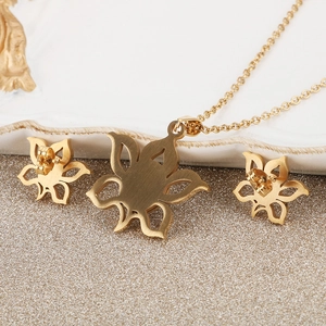Golden hollow sunflower jewelry set with necklace and stud earrings on ceramic tray
