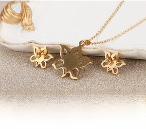 Detail of gold hollow sunflower jewelry set with brushed matte texture on a white plate
