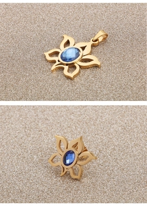 Detailed macro view of a gold flower pendant with a blue oval gemstone inlay