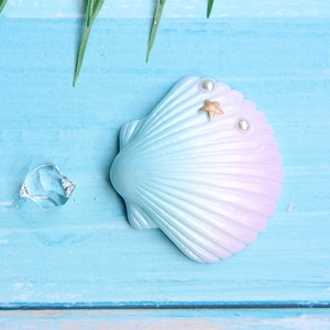Macro detail of gradient resin shell with mini starfish and pearls for DIY crafts