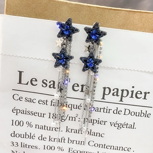 Detail of blue crystal star earring with elegant silver tassel and white pearl drop