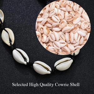 Handmade Bohemian cowrie shell necklace set with black cord on a dark textured background