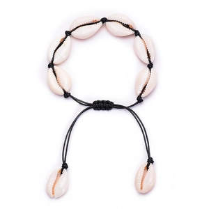 Detail of handmade bohemian shell bracelet with adjustable black braided cord on white base