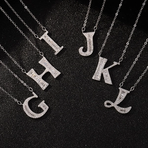 Macro shot of silver S925 letter pendants G to L with shimmering zircon stones