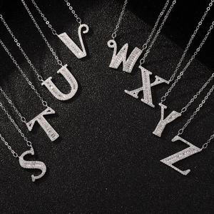 Macro shot of silver letter necklaces S to Z with cubic zirconia pavé on black background
