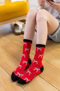 Detail of red crew socks featuring black polka dots and dalmatian pattern on a model