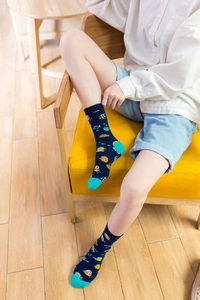 Detail of blue crew socks featuring tropical fish patterns and lime green accents