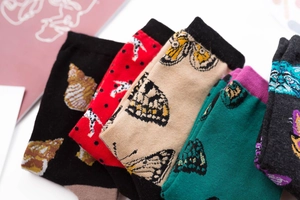 Detailed close-up showing butterfly patterns on colorful mid-calf cotton socks