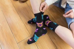 Close-up of cotton mid-calf socks featuring colorful cartoon cat patterns with glasses