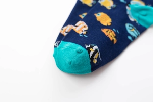 Detailed close-up of cotton crew sock featuring colorful tropical fish patterns on blue