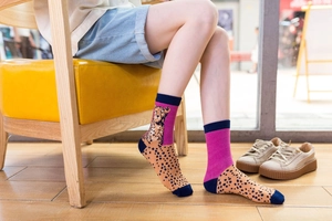 Detailed view of leopard print mid-calf socks in orange and purple for stylish women