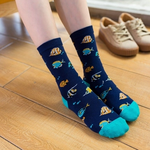 Mid-calf cotton socks with tropical fish patterns and turquoise heels on light wood floor