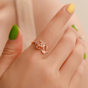 Vintage rose flower open ring in rose gold finish on model's hand jewelry close-up