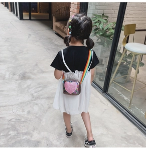 Détail du sac holographique en forme de cœur avec bandoulière arc-en-ciel sur enfant