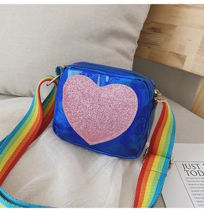 Détail du sac coeur bleu laser avec paillettes roses et bandoulière rayée arc-en-ciel