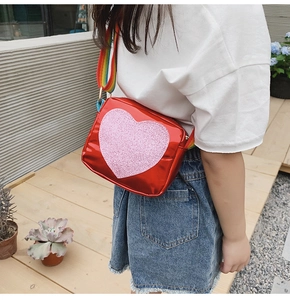 Détail du sac à bandoulière rouge en cœur pour filles avec sangle arc-en-ciel