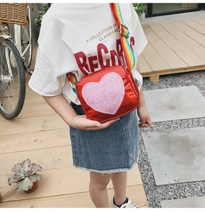 Détail du sac à bandoulière cœur rouge pour filles avec sangle arc-en-ciel et cœur pailleté