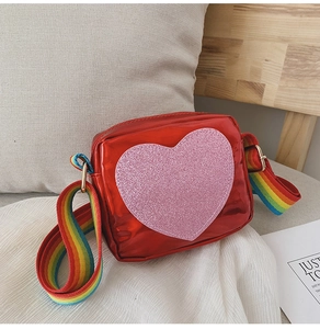 Détail du sac à bandoulière rouge en forme de cœur pour filles avec sangle arc-en-ciel