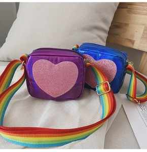 Détail de sacs cœur métallisés bleu et violet avec bandoulières tressées arc-en-ciel