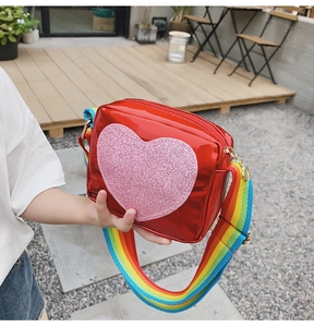 Vue latérale du sac bandoulière rouge pour enfant avec cœur à paillettes roses