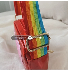 Détail du sac bandoulière rouge brillant avec sangle arc-en-ciel et patch pailleté