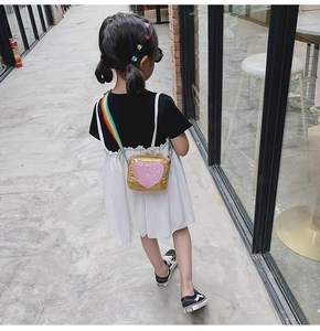 Détail du sac à bandoulière doré pour filles avec cœur pailleté et sangle arc-en-ciel