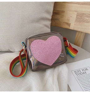 Détail du cœur à paillettes roses et de la bandoulière arc-en-ciel sur le sac pour enfant