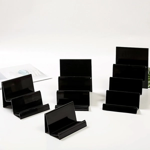 Tiered black acrylic display stands for cards and phones on a clean white background