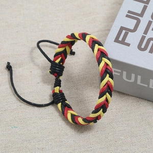 Detail view of woven colorful wax cord bracelet with adjustable knot on textured cloth