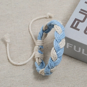 Close-up of hand-woven light blue and cream cotton rope bracelet with adjustable knot