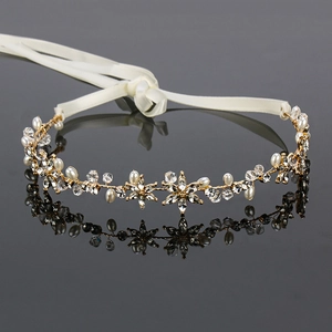 Detailed macro view of golden flower headband with white pearls and sparkling crystals