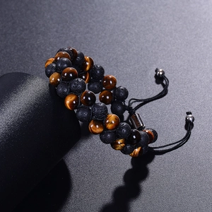 Double-row tiger eye and lava stone braided bracelet on a black display pedestal