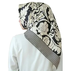Detail showing elegant floral pattern and polka dot border on black square hijab