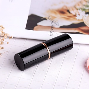 Dettaglio pennello trucco retrattile con scocca nera e anello elegante in oro rosa lucido