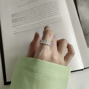 Close-up of a silver 925 sterling silver ring with square zircon on an open book